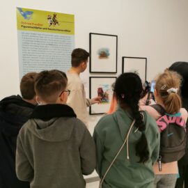 Museumsführer:innen führen Schüler durch die Otfried-Preußler-Austellung